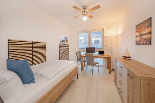 a bedroom with a bed and a desk with a table at FeWo Lieblingsort in Loddin