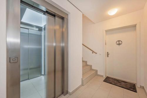 a hallway with a glass door and stairs at FeWo Lieblingsort in Loddin