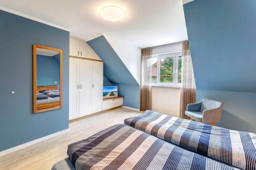 a bedroom with blue walls and a bed and a chair at FeWo Am Pier 7a in Loddin