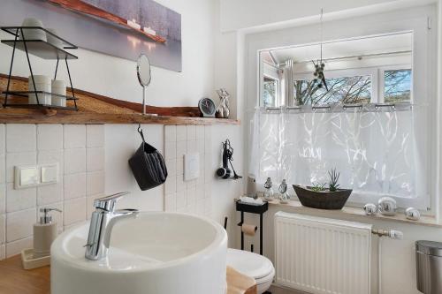 a white bathroom with a sink and a window at Wintergarten Am Thingplatz in Rinteln