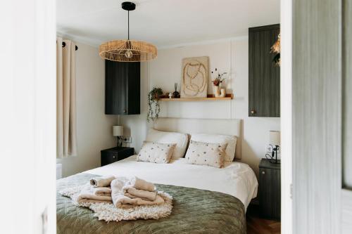 a bedroom with a bed with towels on it at 't Veluws Nest - Knus Chalet Veluwe - Hoenderloo, Honden welkom in Hoenderloo