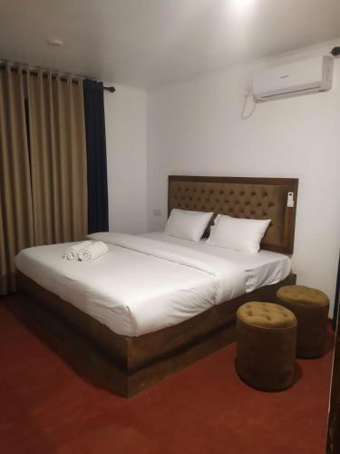 a bedroom with a large bed and two ottomans at Thotupala Eco Lodge in Nilweligama
