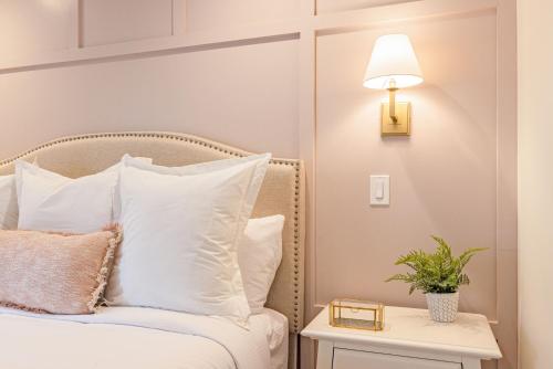 a bed with white pillows and a lamp on a table at Kildahl House - Boutique Farmhouse Suite #1 in West Dundee