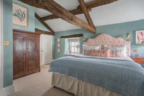 a bedroom with a large bed with a pink headboard at The King's Arms in Hawkshead