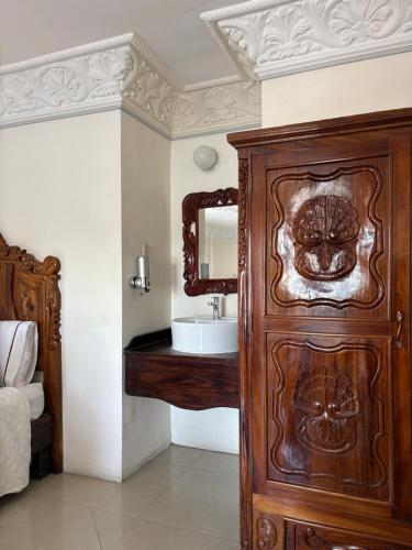 ein Badezimmer mit einem Holzschrank neben einem Waschbecken in der Unterkunft Hotel Royal Puebla in Puebla