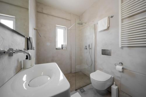 a white bathroom with a sink and a toilet at Blue Pine Villa in Marathon