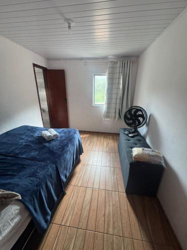 a bedroom with a bed and a bench in it at Família Ebeneze in Santa Maria Madalena