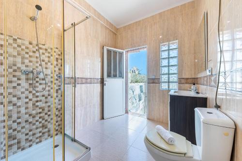 a bathroom with a toilet and a glass shower at Chalet del Lago in Torrevieja
