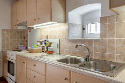 a kitchen with a sink and a stove at Traditional House in Velies in Áyios Sarándos