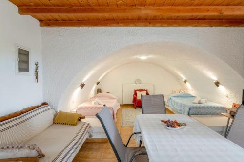 a room with two beds and a table and chairs at Traditional House in Velies in Áyios Sarándos