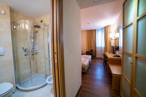 a bathroom with a shower and a toilet and a sink at Hotel Tiffany Milano in Trezzano sul Naviglio