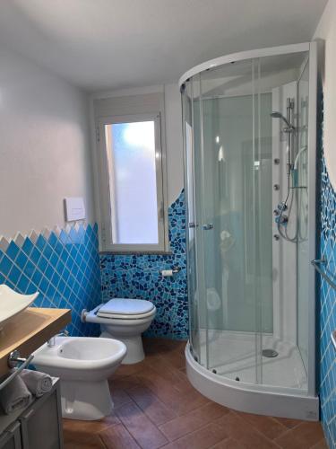 a bathroom with a toilet and a glass shower at Appartamento Blue in Cala Gonone