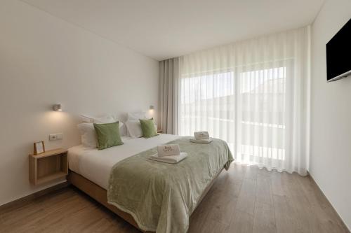 a bedroom with a large bed with a large window at Terra - B&P Infinity House in São Martinho do Porto