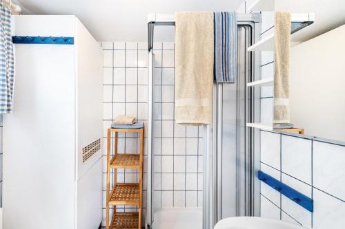 a bathroom with white tiled walls and a shower at Möve Aba Bungalow 66 in Rerik