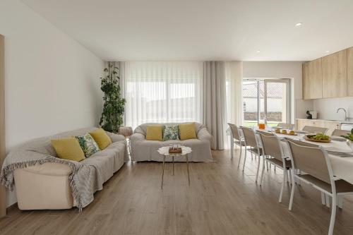 a living room and kitchen with a couch and a table at Terra - B&P Infinity House in São Martinho do Porto