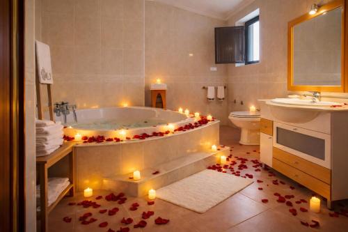 a bathroom with a tub with candles on the floor at Suíte Private balcony Hot Tub in Aguda