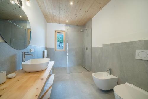 a bathroom with a tub and a sink and a toilet at Naturapartments Alpreid Zirbe in San Pancrazio dʼUltimo