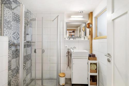 a white bathroom with a shower and a sink at Ferienwohnung Zur Alten Scheune in Balingen