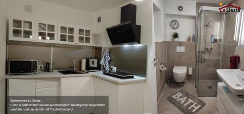 a bathroom with a sink and a tv on a counter at Gästezimmer La Siesta in Ötisheim