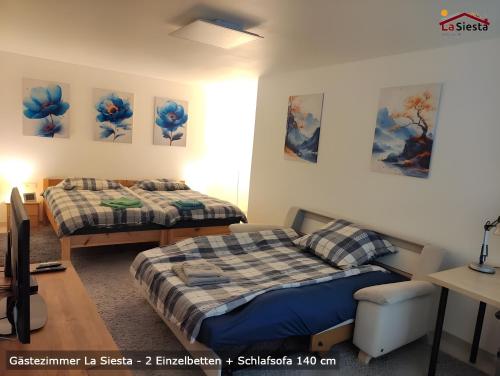 a room with two beds and a desk at Gästezimmer La Siesta in Ötisheim