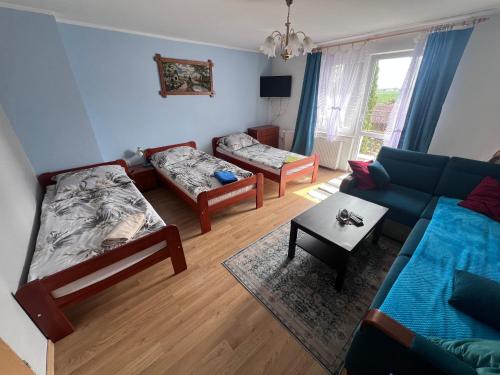 a living room with a couch and a table at Gospodarstwo Agroturystyczne E K Szabowscy in Jeżewo