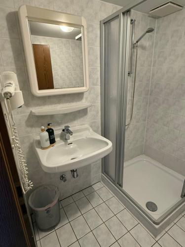 a white bathroom with a sink and a shower at Gästehaus Klausenhof in Klausen