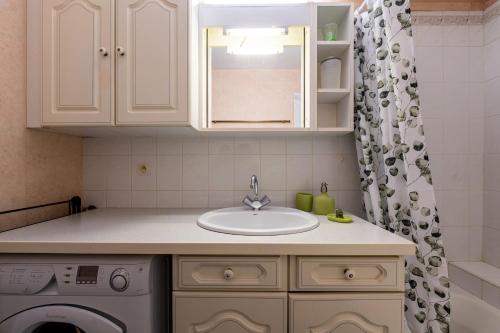 a kitchen with a sink and a washing machine at Résidence du parc in Thônes