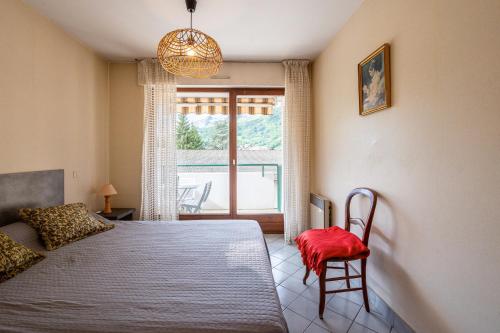 a bedroom with a bed and a chair and a window at Résidence du parc in Thônes