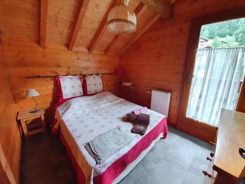 a bedroom with a bed in a wooden cabin at Chalet Du Saix - Sauna in La Chapelle-dʼAbondance