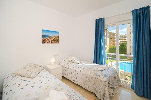 two beds in a bedroom with a balcony at Rotonda Spaniahome in L'Alfàs del Pi