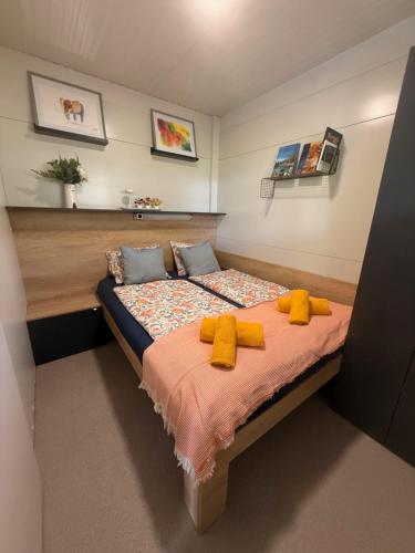 a bedroom with a bed with two yellow pillows on it at Hiška Radolca - Camping Radovljica in Radovljica