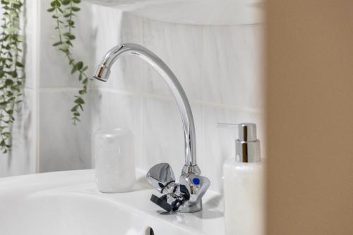 a sink with a faucet on a white sink at Ferienwohnung an der Kriemhildmühle in Xanten