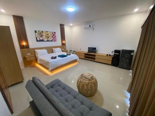 a large bedroom with a bed and a couch at Yaya BCB in Gili Meno