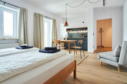 a bedroom with two beds and a table and a chair at Alte Seifensiederei - Thay in Bad Tölz