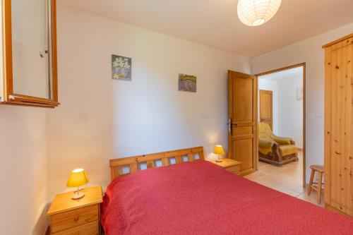 a bedroom with a red bed and a chair at Les Sources Gîte La Remise in Chambonas
