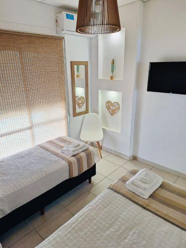 a bedroom with two beds and a tv and a window at C1 Suite in Las Varillas