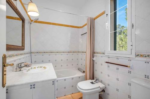 a bathroom with a sink and a tub and a toilet at Villa Playa Felostal in Palma de Mallorca