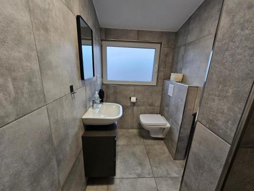 a bathroom with a sink and a toilet at Neubau Ferienwohnung mit Balkon in Gronau