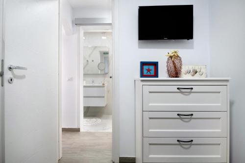 a bathroom with a dresser with a tv on a wall at Casa Marion in El Golfo