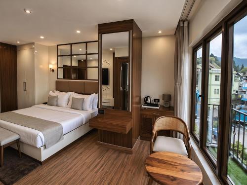 a hotel room with a bed and a balcony at Valmere Chery Blossom Suites in Shillong