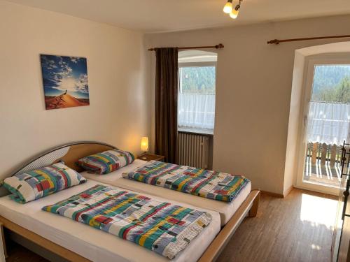 a bedroom with two beds and two windows at Ferienhof Rohrbachhof in Schiltach