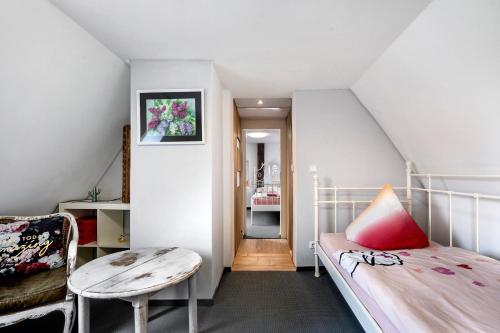 a small attic bedroom with a bed and a table at Wünsch Dir was in Großweitzschen