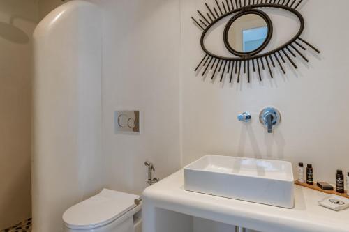 a bathroom with a toilet and a mirror on the wall at Aeolos Villa Cleo in Agkidia
