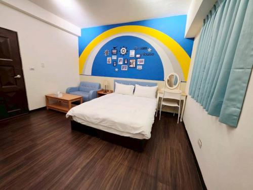 a bedroom with a bed and a rainbow painted on the wall at 暖かさ城宿 in Taichung