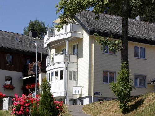 a large white building with a balcony at Ferienwohnungen Uhren Allgaier in Schönwald
