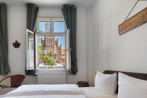 a bedroom with a bed and a window at Kurfürstensuite in Brandenburg an der Havel