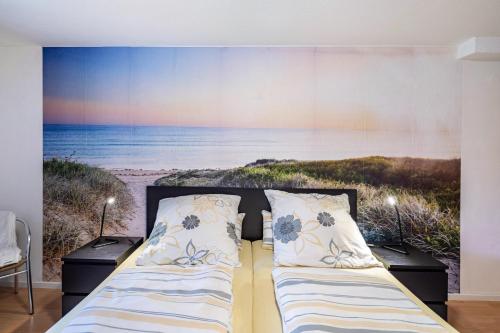 a bedroom with a bed with a painting of the beach at Ferienwohnung Waldeckchen in Waldeck