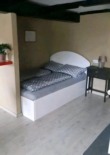 a white bed in a room with a table at Abendsonne in Wurster Nordseeküste