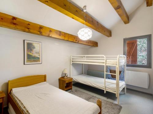 a bedroom with two bunk beds and a ceiling with beams at Chalet Lilette in Font-Romeu-Odeillo-Via