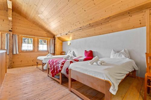 three beds in a room with wooden ceilings at L'Auberge de L'Ours in Vers L'Eglise